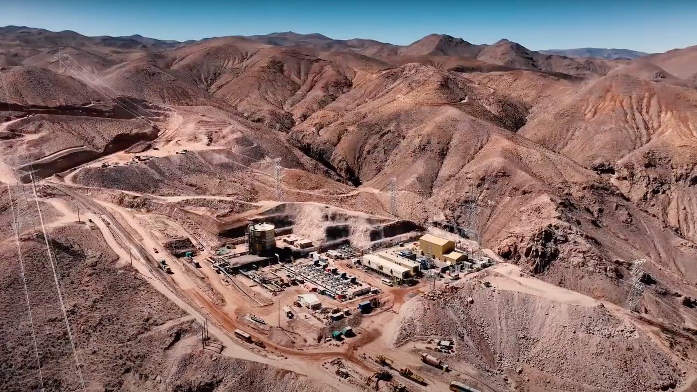 Aerial view of an industrial site surrounded by rugged mountainous terrain.