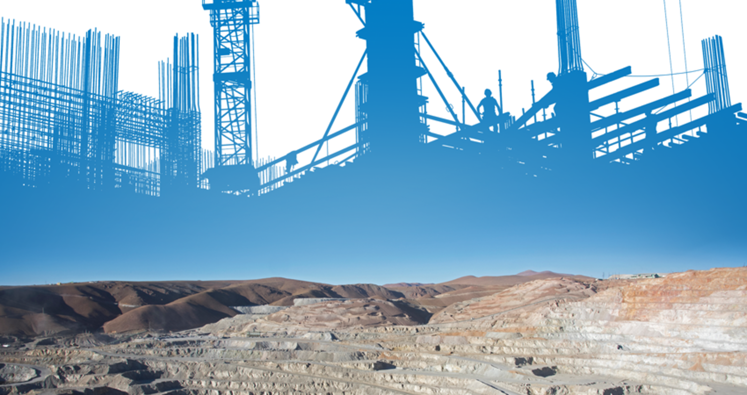 Construction site silhouette above a desert mining landscape.