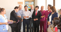 Group of people gathered for ribbon-cutting ceremony at a healthcare facility.