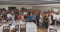 A large group of people posing together in a dining room.