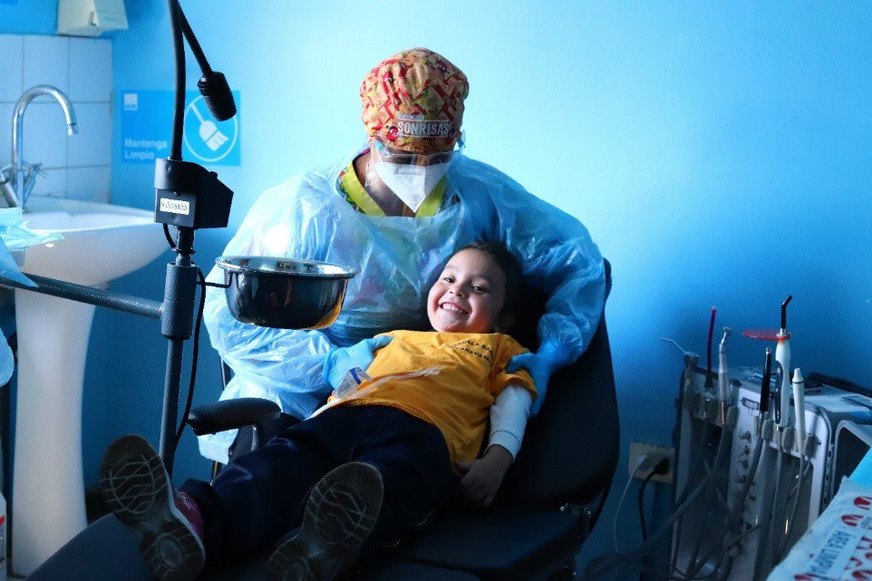 Dentist and smiling child in a dental clinic, child sitting in a dental chair.