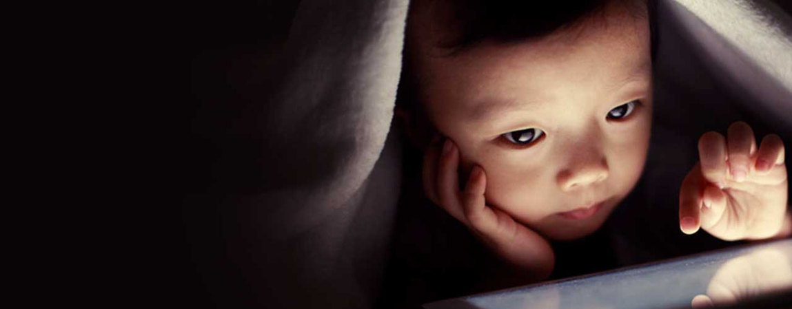 Copper is... A child under a blanket looks intently at a tablet, with soft lighting illuminating their face.