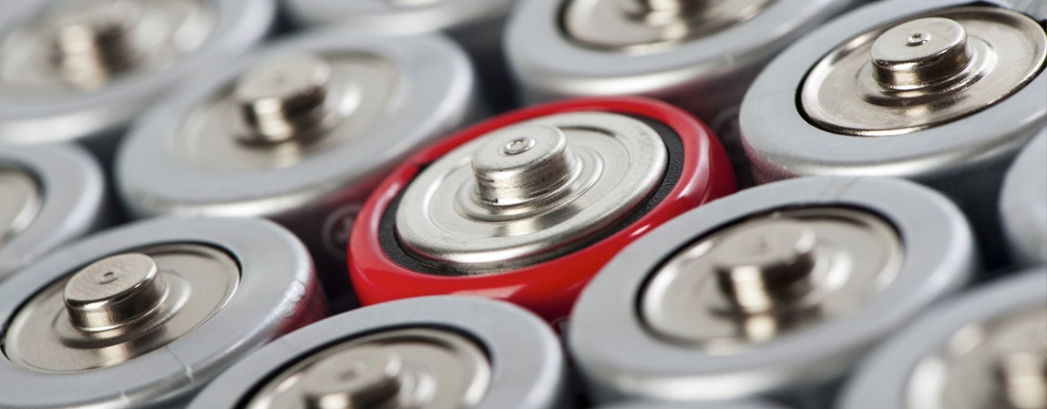 ¿Sabía usted que...? Close-up of various silver batteries with one red battery standing out.