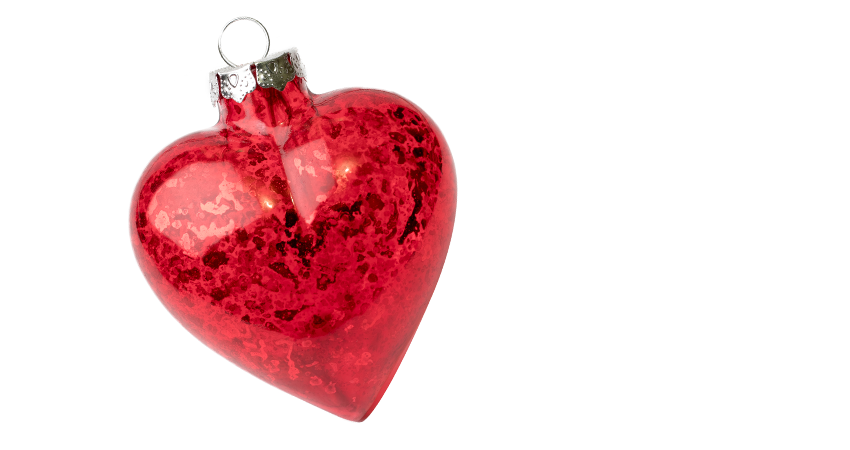 Red heart-shaped Christmas ornament with a silver cap on a white background.