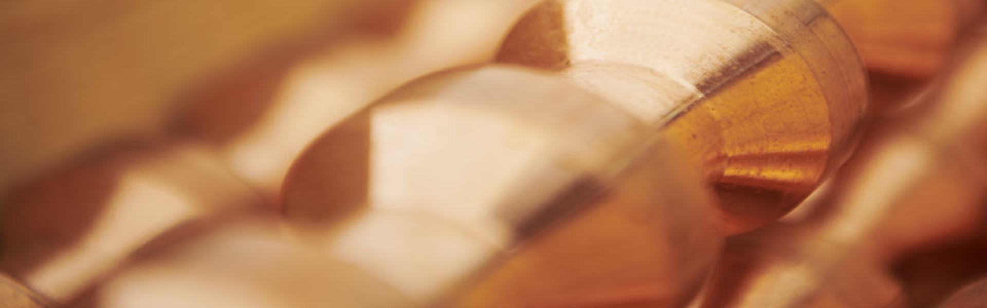 Close-up of polished copper pieces with a warm, metallic sheen and smooth surfaces.