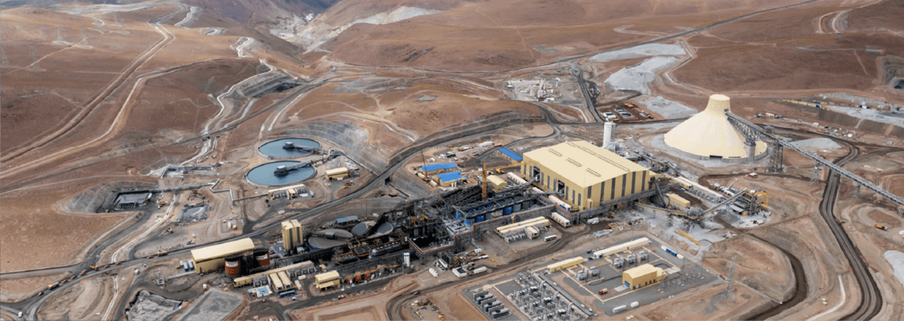 Large mining facility in a desert landscape, with industrial buildings and equipment visible.